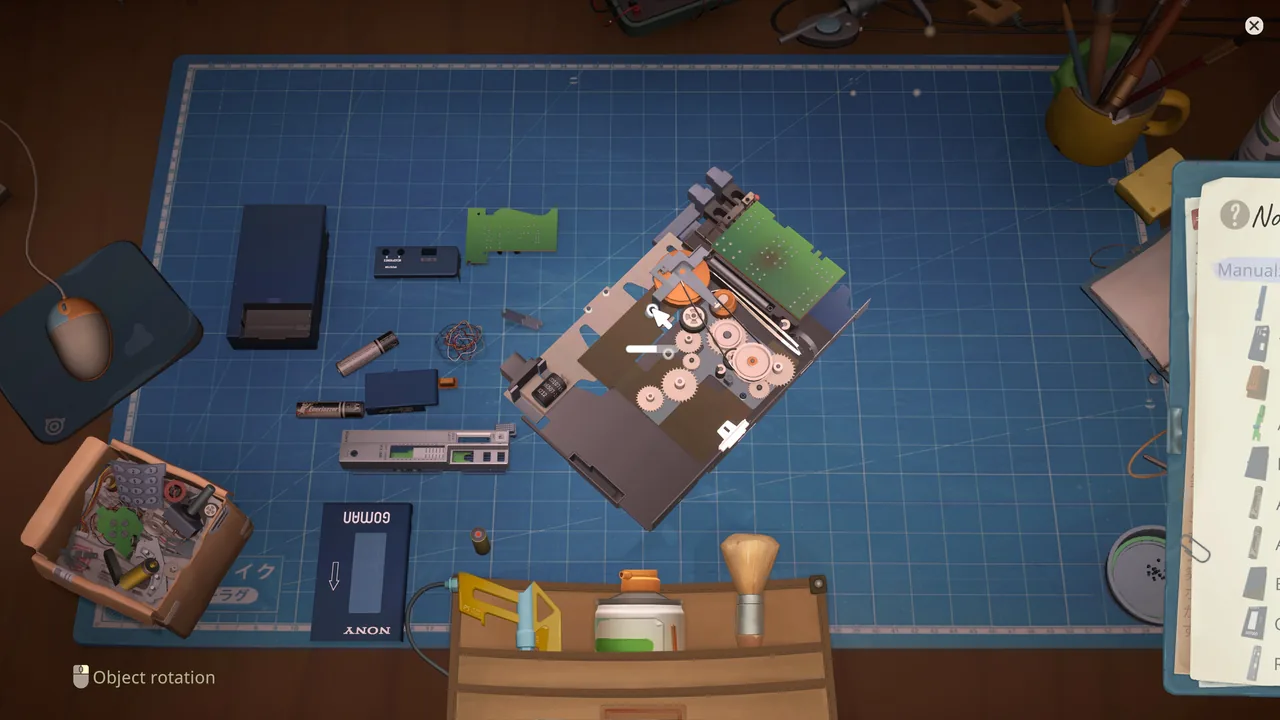 Disassembled electronic device with boards, batteries, gears, and casing on the workbench